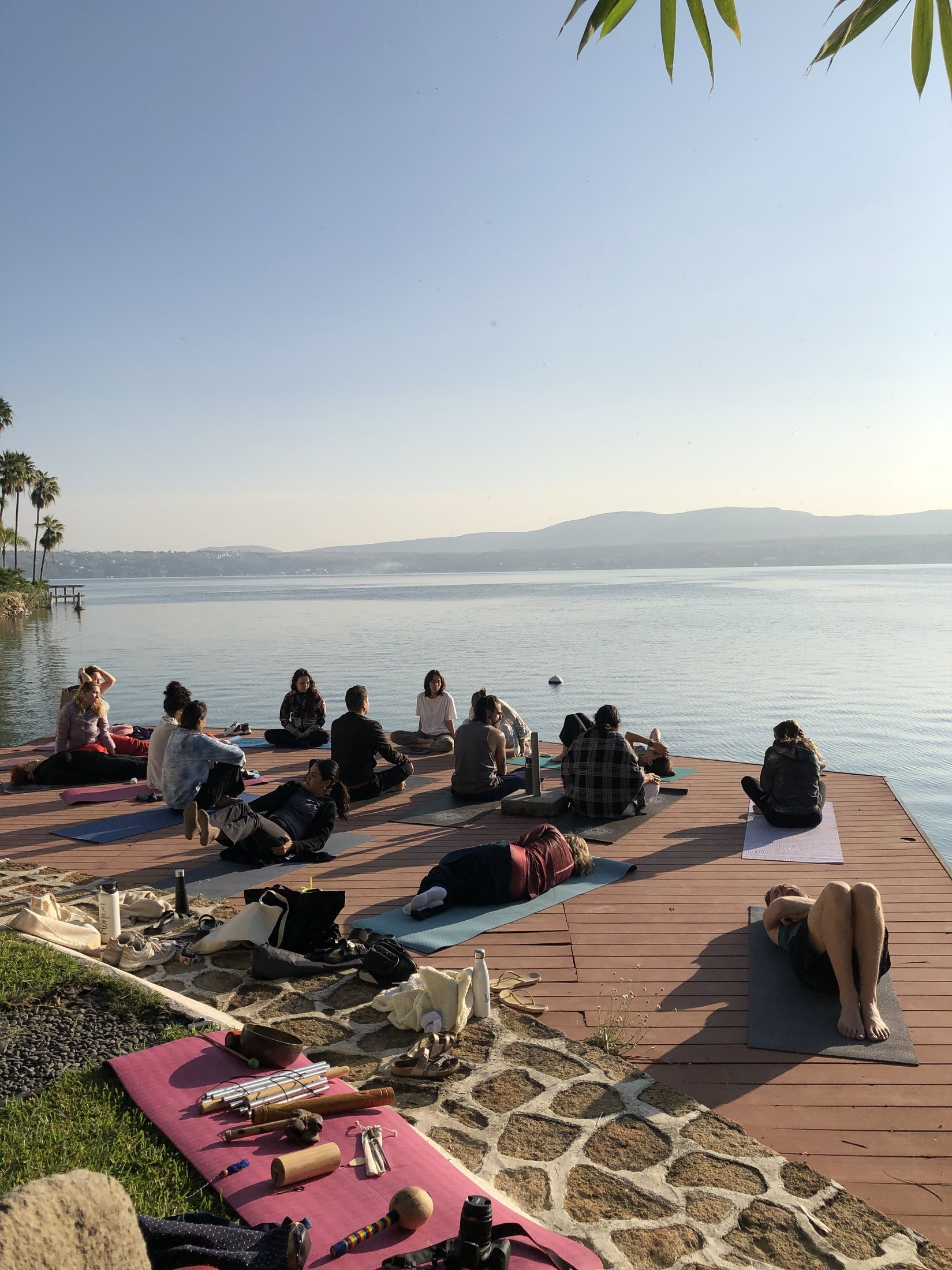 Eine Gruppe ruht und sitzt zusammen auf einem Steg am See während einer Session