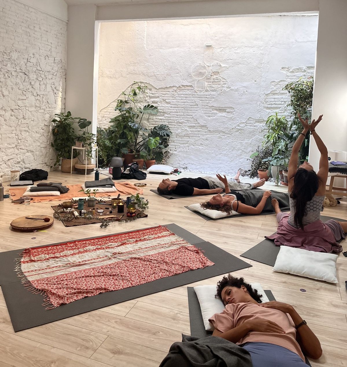 Teilnehmende ruhen und bewegen sich auf Matten in einem hellen Studio während eines Dreamwave Immersive Trainings