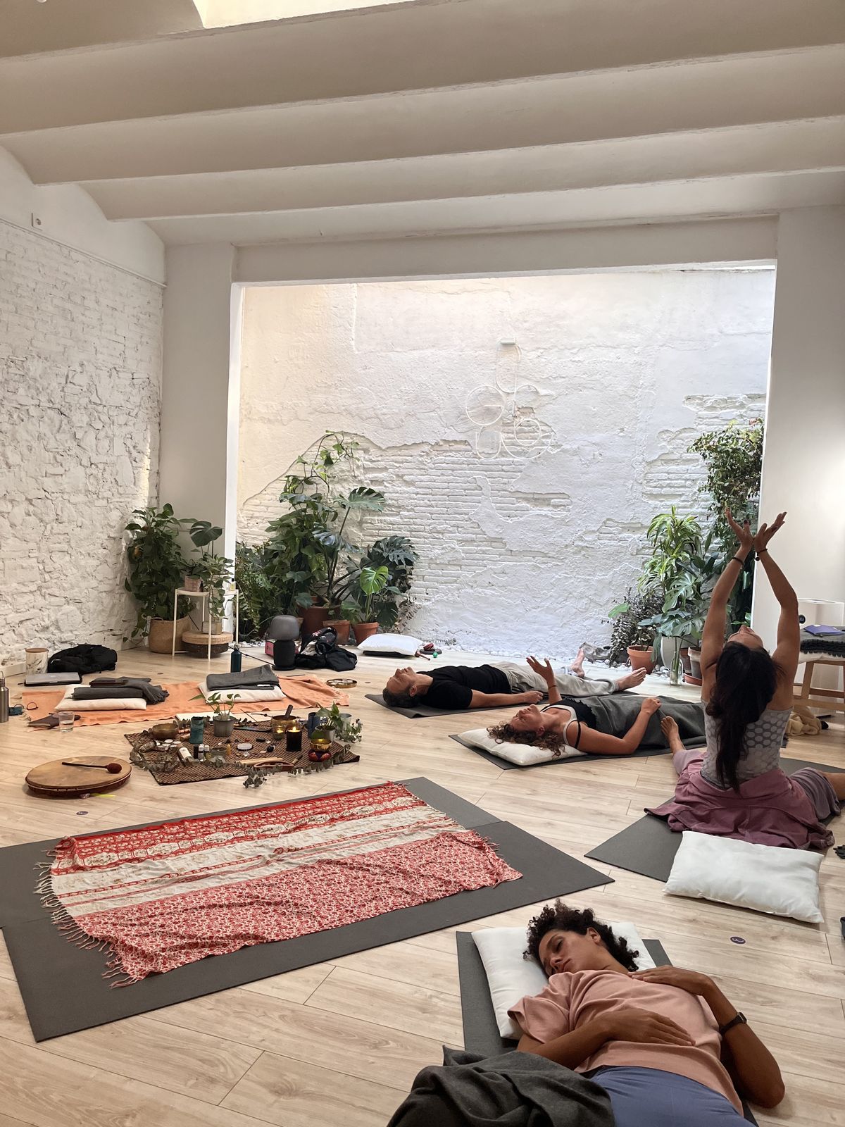 Participants resting and moving on mats in a bright studio during a Dreamwave immersive training