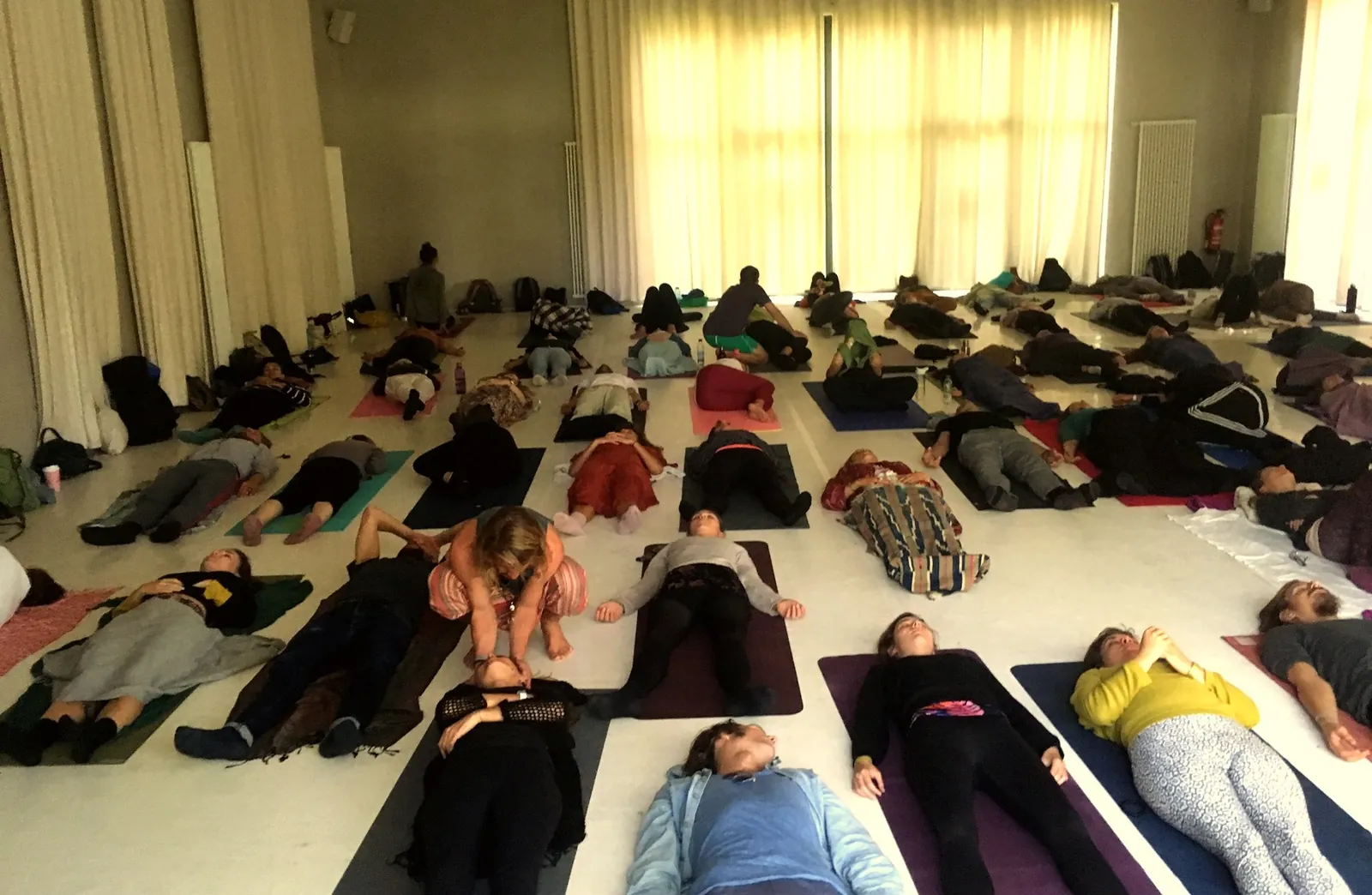 Participants lying on mats in a bright room during a Dreamwave innerdance session