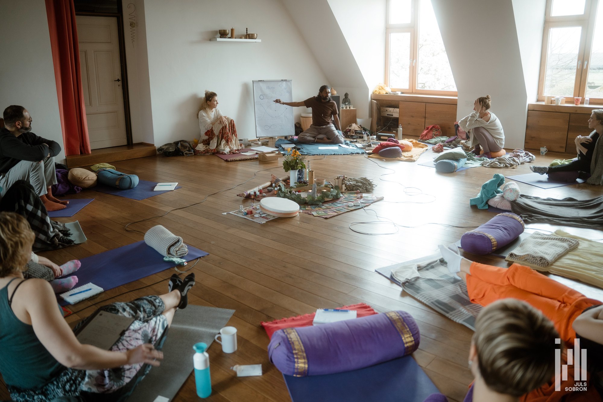 Eine Gruppe sitzt in einem Kreis bei einem Präsenztraining